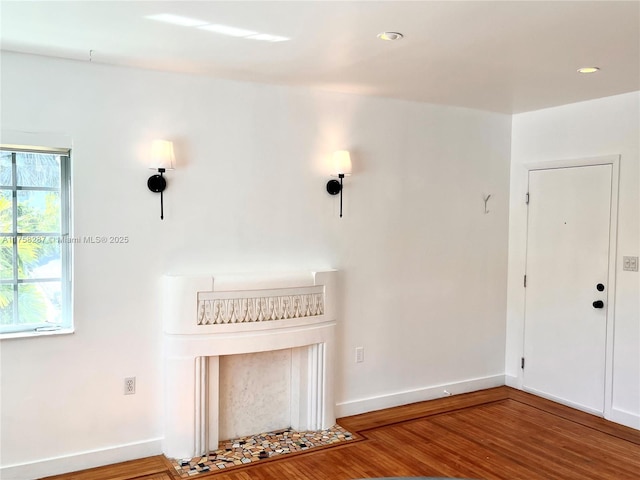 unfurnished living room with baseboards and wood finished floors