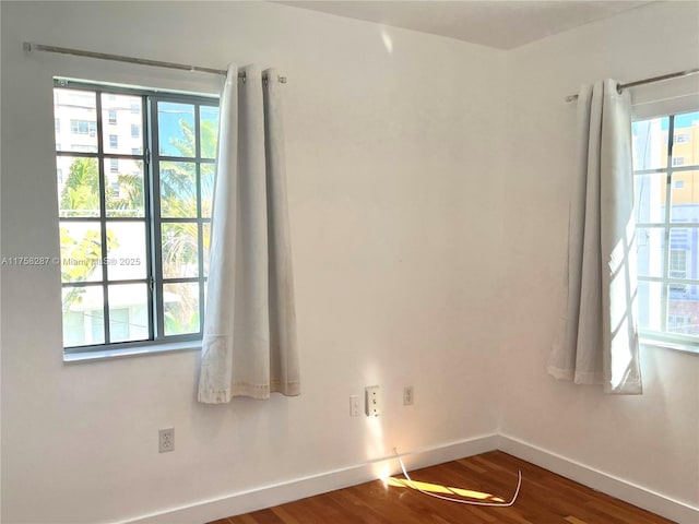 empty room with baseboards and wood finished floors