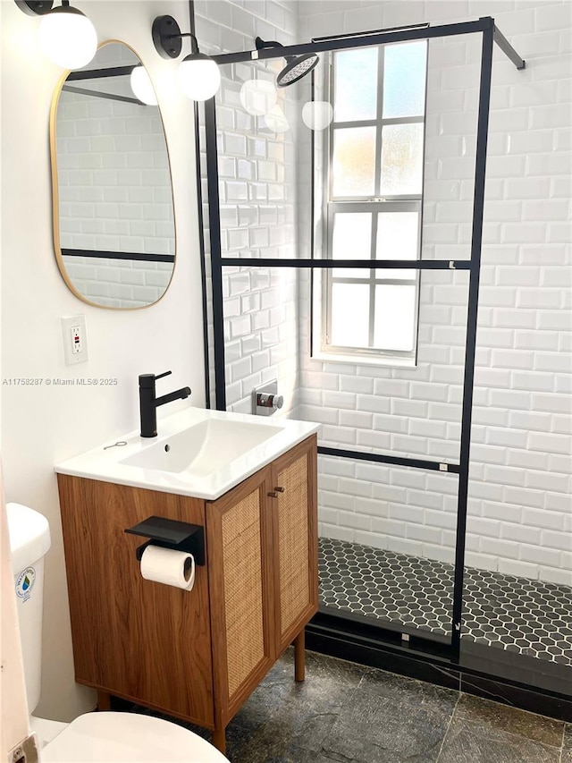 full bathroom featuring a shower stall, toilet, and vanity