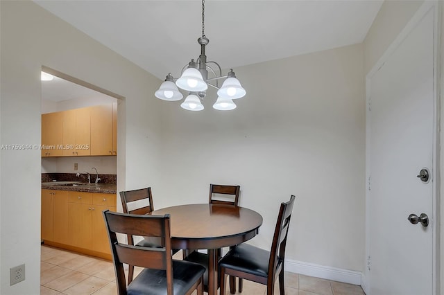 dining area featuring a chandelier, light tile patterned flooring, and baseboards