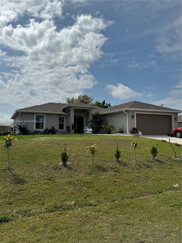 single story home featuring a garage, driveway, a front lawn, and stucco siding