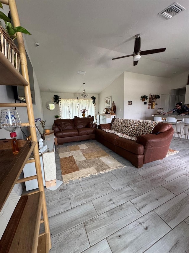 unfurnished living room with lofted ceiling, wood finish floors, visible vents, and a ceiling fan