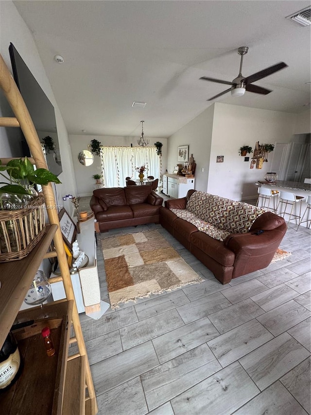 living area with ceiling fan, lofted ceiling, visible vents, and wood tiled floor