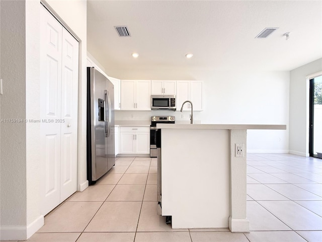 kitchen with stainless steel appliances, light countertops, visible vents, and light tile patterned floors