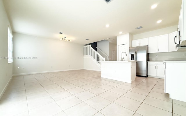 kitchen featuring a center island with sink, stainless steel appliances, light countertops, open floor plan, and a sink