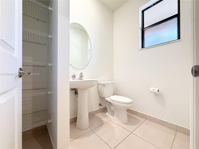 bathroom featuring toilet, baseboards, and tile patterned floors