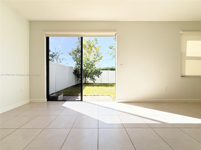 tiled spare room featuring baseboards