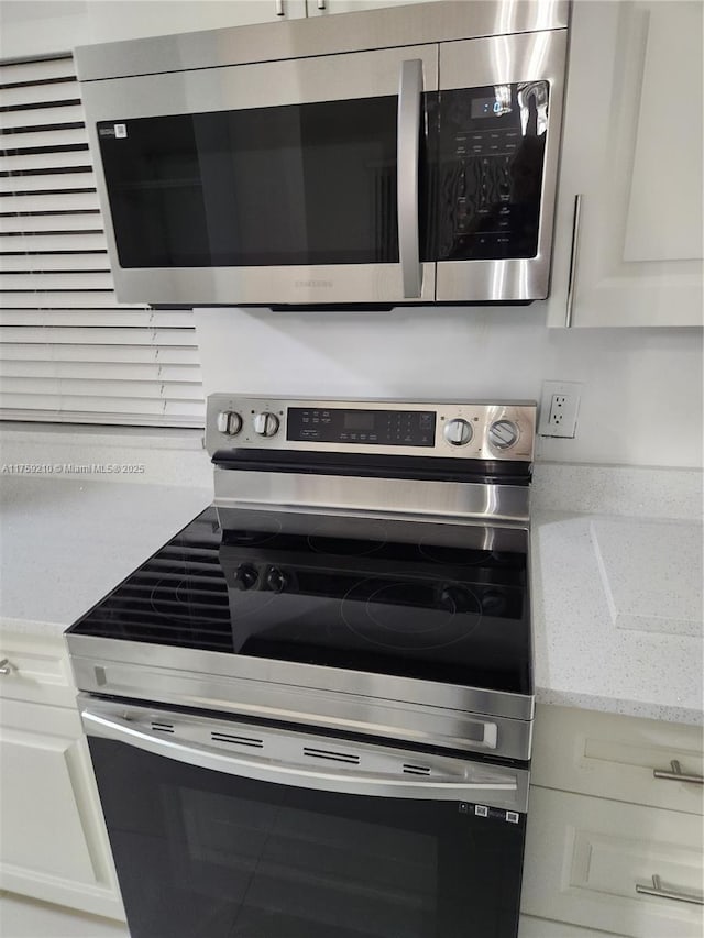 kitchen with appliances with stainless steel finishes and light stone counters