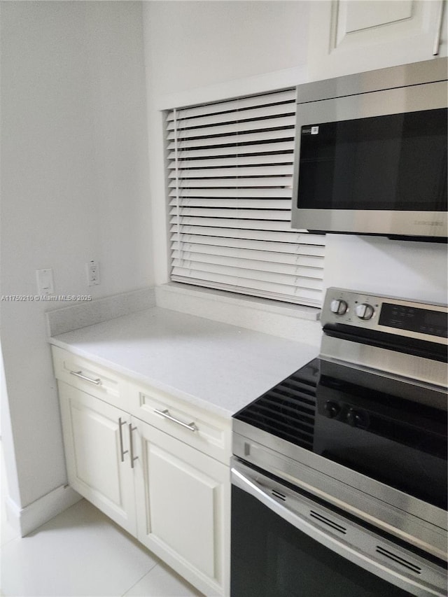 kitchen featuring light countertops, appliances with stainless steel finishes, and white cabinetry