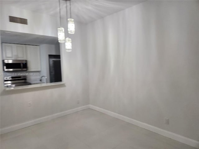 unfurnished dining area featuring visible vents and baseboards