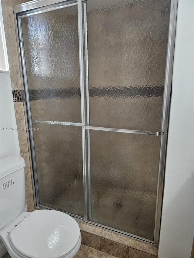 full bathroom with a stall shower and toilet