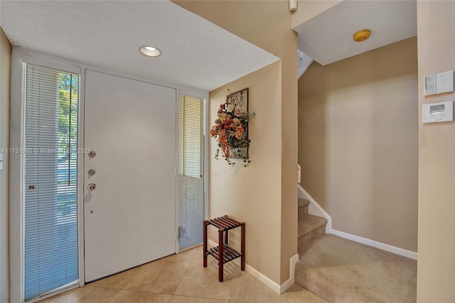 foyer entrance with light tile patterned floors, stairs, baseboards, and recessed lighting