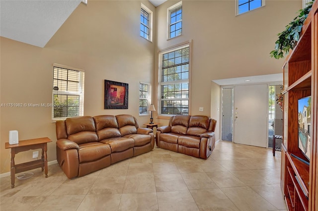 living area with a healthy amount of sunlight, baseboards, and light tile patterned flooring