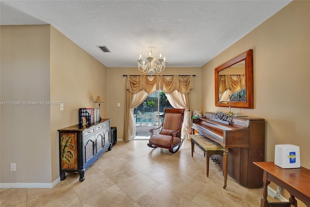 living area featuring visible vents, a textured ceiling, baseboards, and an inviting chandelier