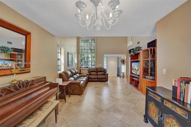 living area with an inviting chandelier, light tile patterned floors, and visible vents