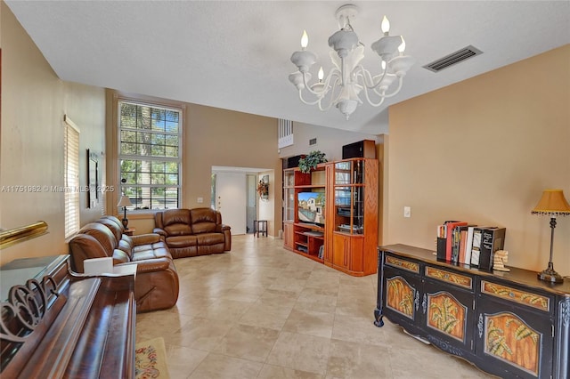 living room with an inviting chandelier, light tile patterned floors, and visible vents