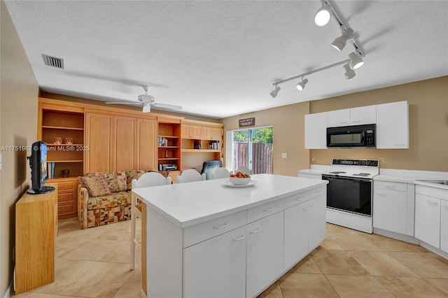 kitchen with black microwave, white electric range, a breakfast bar, visible vents, and a center island