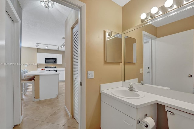 bathroom featuring tile patterned flooring, a textured ceiling, and vanity