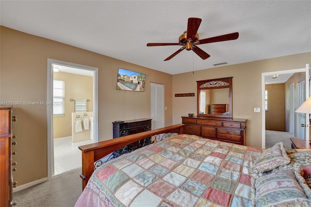 bedroom with baseboards, visible vents, connected bathroom, a ceiling fan, and carpet