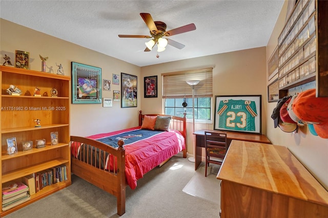 bedroom featuring a textured ceiling, carpet flooring, and a ceiling fan