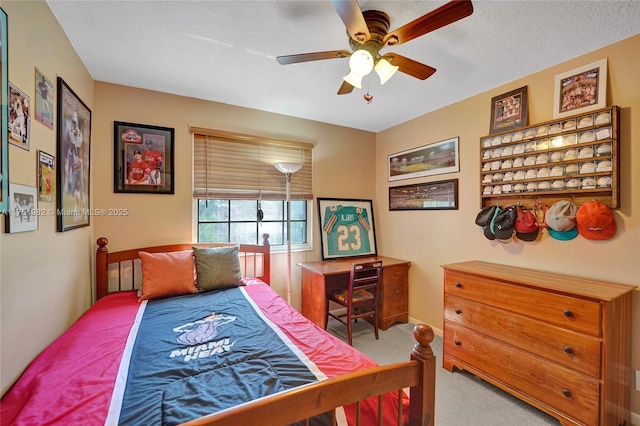 carpeted bedroom featuring a textured ceiling and ceiling fan