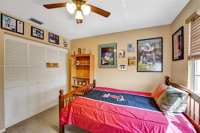 carpeted bedroom with ceiling fan, a closet, and visible vents