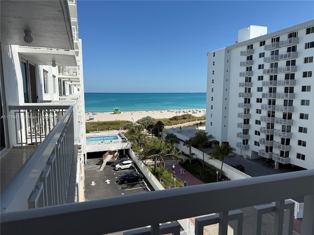 balcony featuring a beach view and a water view