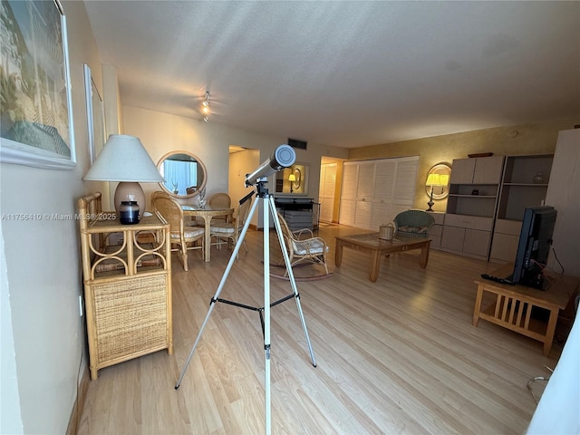 recreation room featuring visible vents, a textured ceiling, and wood finished floors