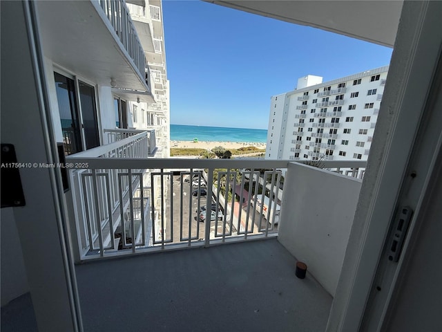 balcony with a water view and a beach view