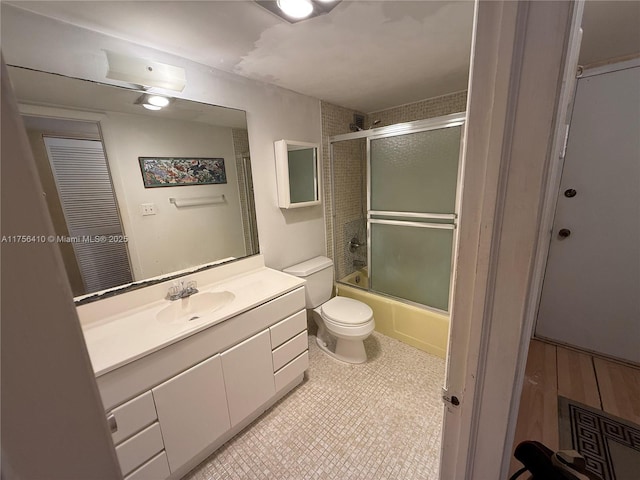 bathroom with bath / shower combo with glass door, vanity, and toilet