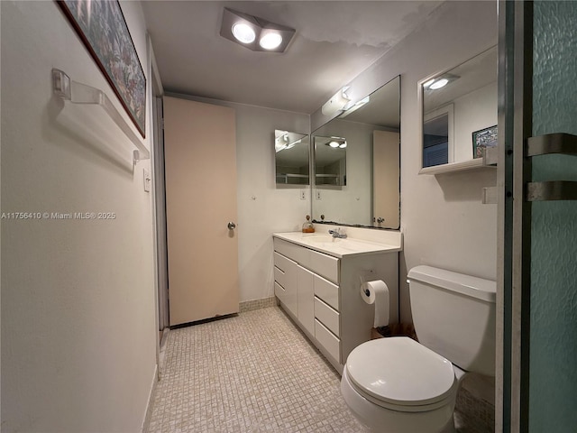 bathroom with vanity, toilet, and baseboards