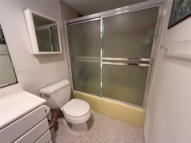 bathroom featuring shower / bath combination with glass door, vanity, toilet, and tile patterned floors