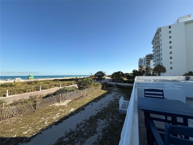 property view of water with fence and a view of the beach