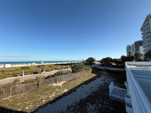 water view with fence and a view of the beach