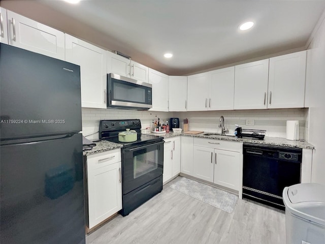 7100 NW 17th St Unit 111, Plantation, FL 33313 - kitchen featuring black appliances, a sink, white cabinets, light wood-style flooring, and recessed lighting