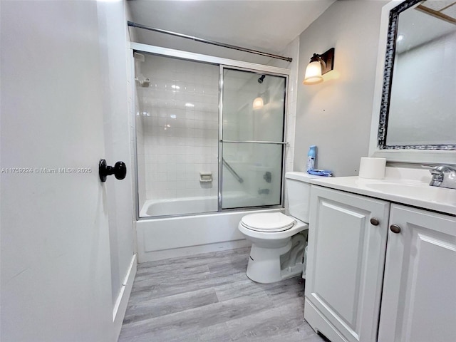 7100 NW 17th St Unit 111, Plantation, FL 33313 - full bath featuring wood finished floors, vanity, enclosed tub / shower combo, and toilet