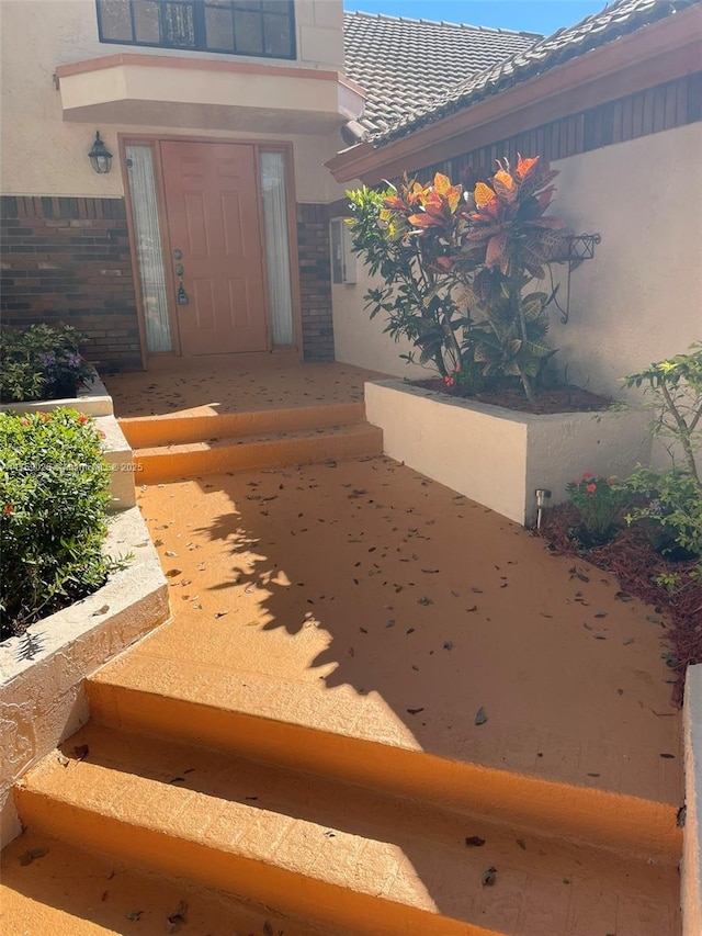 entrance to property with stucco siding and a tiled roof