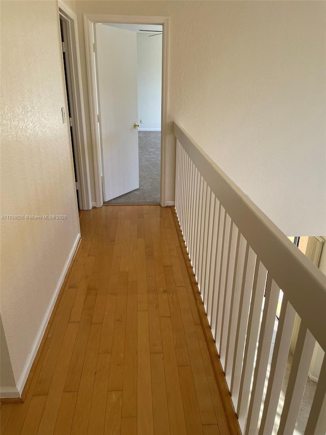 hall featuring baseboards and wood finished floors