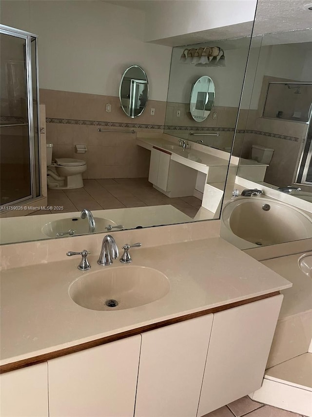 full bath with tile patterned flooring, tile walls, toilet, and vanity