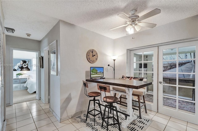 dining area with french doors, ceiling fan, a textured ceiling, and light tile patterned floors