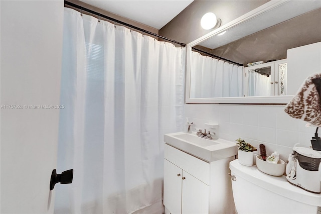 bathroom with tile walls, a shower with shower curtain, toilet, vanity, and backsplash