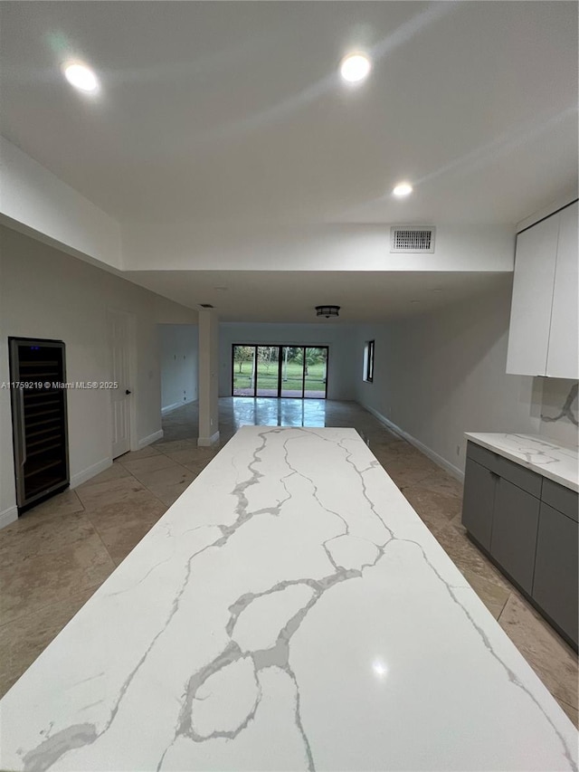 kitchen featuring visible vents, modern cabinets, light stone counters, gray cabinets, and recessed lighting