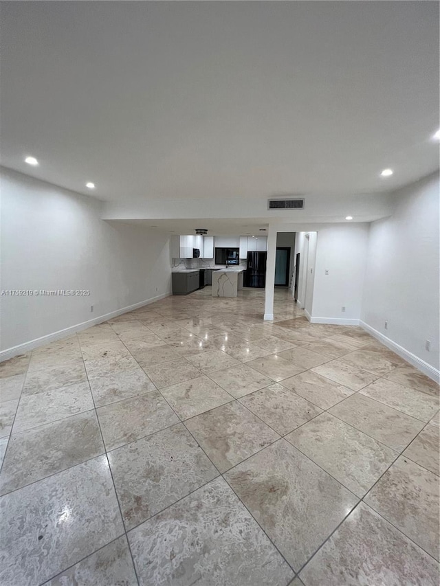 unfurnished living room featuring baseboards, visible vents, and recessed lighting