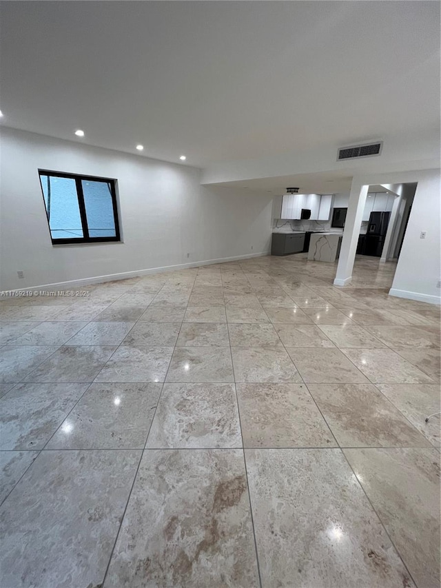 unfurnished living room with baseboards, visible vents, and recessed lighting