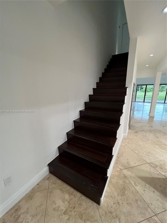 staircase featuring baseboards