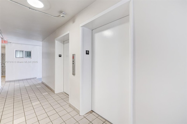 hall with elevator and light tile patterned flooring