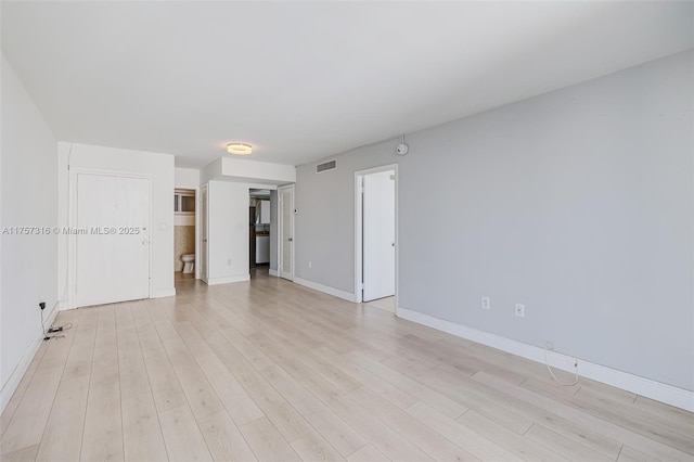 unfurnished room with light wood-style flooring, visible vents, and baseboards