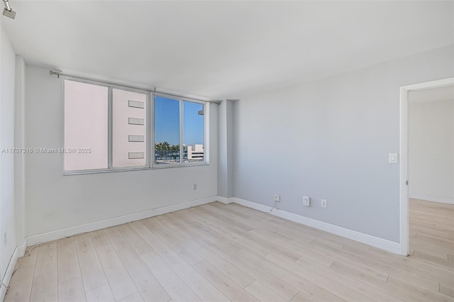 unfurnished room featuring baseboards and wood finished floors