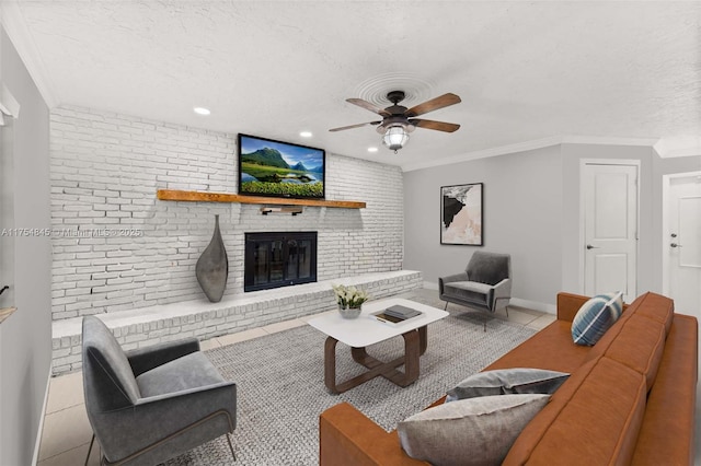 tiled living room with brick wall, ceiling fan, ornamental molding, a textured ceiling, and a fireplace