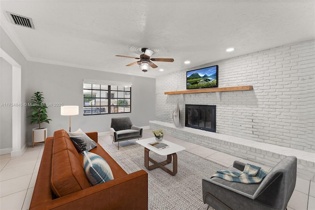 living room with light tile patterned floors, visible vents, brick wall, a textured ceiling, and a brick fireplace